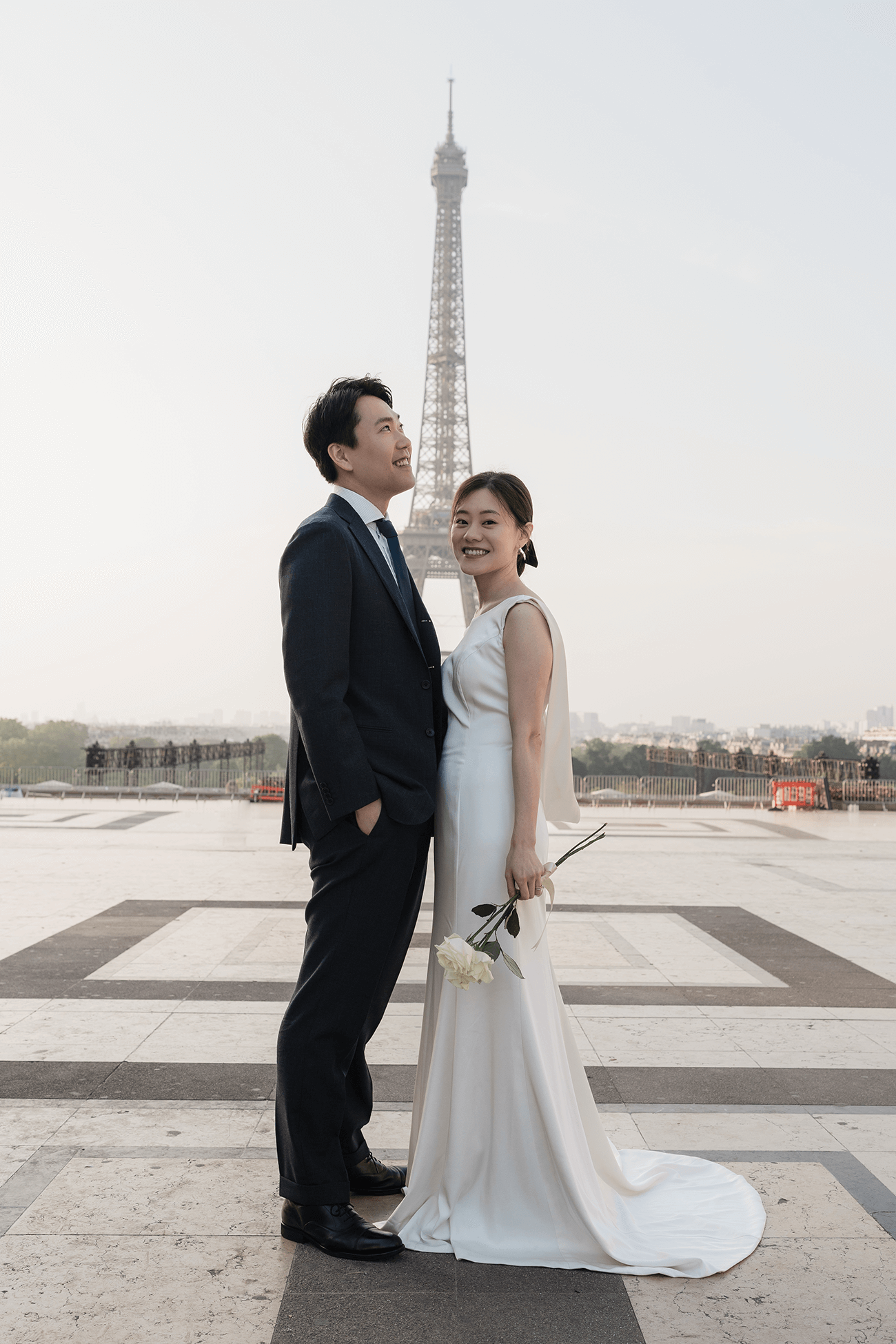 パリ・トロカデロ広場からエッフェル塔を背景に優美に佇む新郎新婦。朝の柔らかな光に包まれた、気品あふれるパリのフォトウェディング。Totteがプロデュースする、映画のようにロマンチックでタイムレスなエッフェル塔前での前撮りシーン。